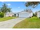 A single-story home features a 2-car garage, green lawn, and long driveway at 8425 Se 177Th Bartram Loop, The Villages, FL 32162