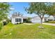 Well-kept single-story home with green shutters, an attached two car garage, and verdant landscaping at 8425 Se 177Th Bartram Loop, The Villages, FL 32162