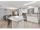 Open kitchen and dining area with light wood flooring and bright white cabinets at 8425 Se 177Th Bartram Loop, The Villages, FL 32162