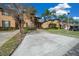 Well-kept townhouse featuring a driveway, sidewalk, and manicured bushes at 906 Calabria Ave, Davenport, FL 33897