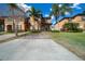 Charming two-story townhouse featuring lush grass, palm trees, manicured bushes, and a driveway at 906 Calabria Ave, Davenport, FL 33897