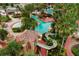 Aerial view of community pool featuring a waterslide, lazy river, and tropical landscaping at 906 Calabria Ave, Davenport, FL 33897