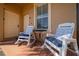 Inviting front porch with two rocking chairs and a small table near the entrance at 906 Calabria Ave, Davenport, FL 33897