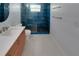 Modern bathroom features a stylish vanity, hexagon tile floor, and a glass shower with blue tiled walls at 925 Northside Dr, Mount Dora, FL 32757