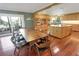 Bright kitchen and dining area with wood floors, island, stainless appliances, and sliding doors to outdoor balcony at 925 Northside Dr, Mount Dora, FL 32757