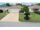 Well-kept one-story home with lush green lawn and a paved driveway leading to an attached garage at 9481 Sw 93Rd Loop, Ocala, FL 34481