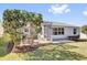 The home's screened patio is adjacent to a landscaped yard with beautiful green grass at 9511 Se 168Th Elderberry Pl, The Villages, FL 32162