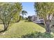 Expansive green backyard featuring mature trees and access to the home's screened-in patio at 9511 Se 168Th Elderberry Pl, The Villages, FL 32162