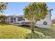 A spacious backyard with a well-maintained lawn, a screened patio, and beautiful landscaping at 9511 Se 168Th Elderberry Pl, The Villages, FL 32162