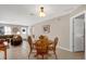 Bright dining area with tile floors, a wooden table, and a view into the living room and front door at 9511 Se 168Th Elderberry Pl, The Villages, FL 32162