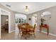 Open-concept dining area featuring tile floors, a wooden table, and archways leading to other rooms at 9511 Se 168Th Elderberry Pl, The Villages, FL 32162