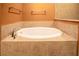 Bright bathroom showcasing a white soaking tub with neutral tone tiles at 1041 Bradford Ridge Dr, Leesburg, FL 34748