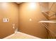 Laundry room featuring neutral tile flooring, neutral walls and wire shelving at 1041 Bradford Ridge Dr, Leesburg, FL 34748