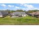 View of a home's backyard and screened patio, nestled in a well-maintained lawn with mature trees and landscaping at 1075 Ceasars Ct, Mount Dora, FL 32757