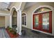 Covered porch featuring a double front door, columns, and arched windows at 1075 Ceasars Ct, Mount Dora, FL 32757