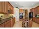 Spacious kitchen with wooden cabinets, tiled backsplash, and a center island for food preparation at 1075 Ceasars Ct, Mount Dora, FL 32757