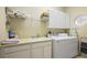 Bright laundry room featuring a modern washer and dryer set, utility sink, and convenient storage shelves and cabinets at 1075 Ceasars Ct, Mount Dora, FL 32757