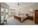 Relaxing main bedroom with soft lighting, neutral tones, and private access to an outdoor seating area at 1075 Ceasars Ct, Mount Dora, FL 32757