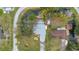 Aerial view of a home with a private pond, multiple docks and wooded yard at 11415 Palmetto Dr, Tavares, FL 32778