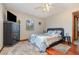 This inviting bedroom features a ceiling fan, wood floors and a window with views of the backyard at 11415 Palmetto Dr, Tavares, FL 32778