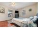 Comfortable bedroom featuring wood floors, ceiling fan and lots of natural light from the large windows at 11415 Palmetto Dr, Tavares, FL 32778