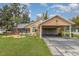 Single-story home featuring a carport and well-maintained front yard with an elegant tropical garden at 11415 Palmetto Dr, Tavares, FL 32778