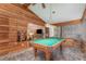 Game room with wood paneling, pool table, and view to the living area at 11415 Palmetto Dr, Tavares, FL 32778