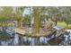 Waterfront property with dock, boat, and rear deck featuring tropical foliage for luxurious outdoor living at 11415 Palmetto Dr, Tavares, FL 32778