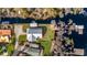 Aerial view of the landscaped property, including the home, dock, and outdoor entertainment area at 12117 Cypress Ln, Clermont, FL 34711