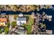 Aerial view of a lakefront home with manicured lawns, a private dock, and lush surrounding trees and water at 12117 Cypress Ln, Clermont, FL 34711