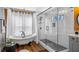 Modern bathroom featuring a luxurious soaking tub, separate glass shower, and hardwood floors at 12117 Cypress Ln, Clermont, FL 34711