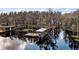 View of the private dock with boat lift and seating area for relaxing on the water at 12117 Cypress Ln, Clermont, FL 34711