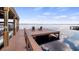 Dock with two Adirondack chairs overlooking a calm lake under a blue sky at 12117 Cypress Ln, Clermont, FL 34711
