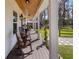 Inviting front porch features rocking chairs, wood ceiling and picturesque landscape views at 12117 Cypress Ln, Clermont, FL 34711