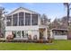 View of the home from the canal featuring a screened in porch and spiral staircase at 12117 Cypress Ln, Clermont, FL 34711