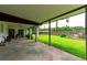 Large back patio with colorful chalk art, picnic table, and a view of the well-maintained lawn at 132 E Belt Ave, Bushnell, FL 33513