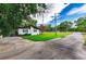 Side view of home and a long driveway, and lush lawn at 132 E Belt Ave, Bushnell, FL 33513