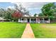 Charming single-story home featuring a well-manicured lawn and a quaint front porch at 132 E Belt Ave, Bushnell, FL 33513