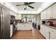 Well-lit kitchen with stainless steel appliances, white cabinets, and wood-look flooring at 132 E Belt Ave, Bushnell, FL 33513