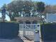 Gated entrance to the community pool with lush greenery and a building in background at 1336 E Schwartz Blvd, The Villages, FL 32159