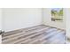 Cozy bedroom featuring durable wood-style flooring and a view of the outdoors from the bright window at 13877 County Road 109F, Lady Lake, FL 32159