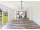 Dining area featuring contemporary light fixture, modern flooring, and sliding door to the backyard at 13877 County Road 109F, Lady Lake, FL 32159