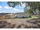 View of the backyard, enclosed by a privacy fence, with a small covered patio and modest landscaping at 151 Shiloh Ave, Lady Lake, FL 32159