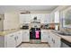 Well-lit kitchen features white cabinets, modern appliances, and neutral countertops at 151 Shiloh Ave, Lady Lake, FL 32159