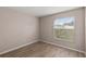 Cozy bedroom featuring wood-look floors and a bright window view at 15318 Margaux Dr, Clermont, FL 34714