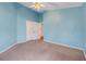 Bedroom painted in light blue, featuring a ceiling fan and neutral carpet for a relaxing ambiance at 16839 Rockwell Heights Ln, Clermont, FL 34711