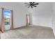 Spacious carpeted bedroom featuring a ceiling fan and a window offering natural light and outdoor views at 16839 Rockwell Heights Ln, Clermont, FL 34711