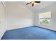 Bedroom with blue carpet, a window offering natural light, and a closet for storage solutions at 16839 Rockwell Heights Ln, Clermont, FL 34711