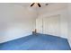 Bedroom with blue carpet, featuring a ceiling fan and a closet, providing a comfortable space at 16839 Rockwell Heights Ln, Clermont, FL 34711