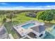 Aerial view of community pool with lounge areas for residents, a clubhouse, and tennis courts at 16839 Rockwell Heights Ln, Clermont, FL 34711